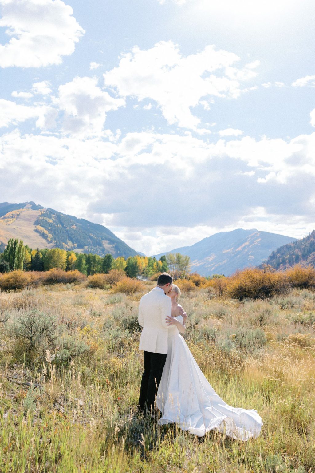 Kayla & Patrick's wedding at the Aspen Chapel and the Caribou Club: the couple walking through the meadow