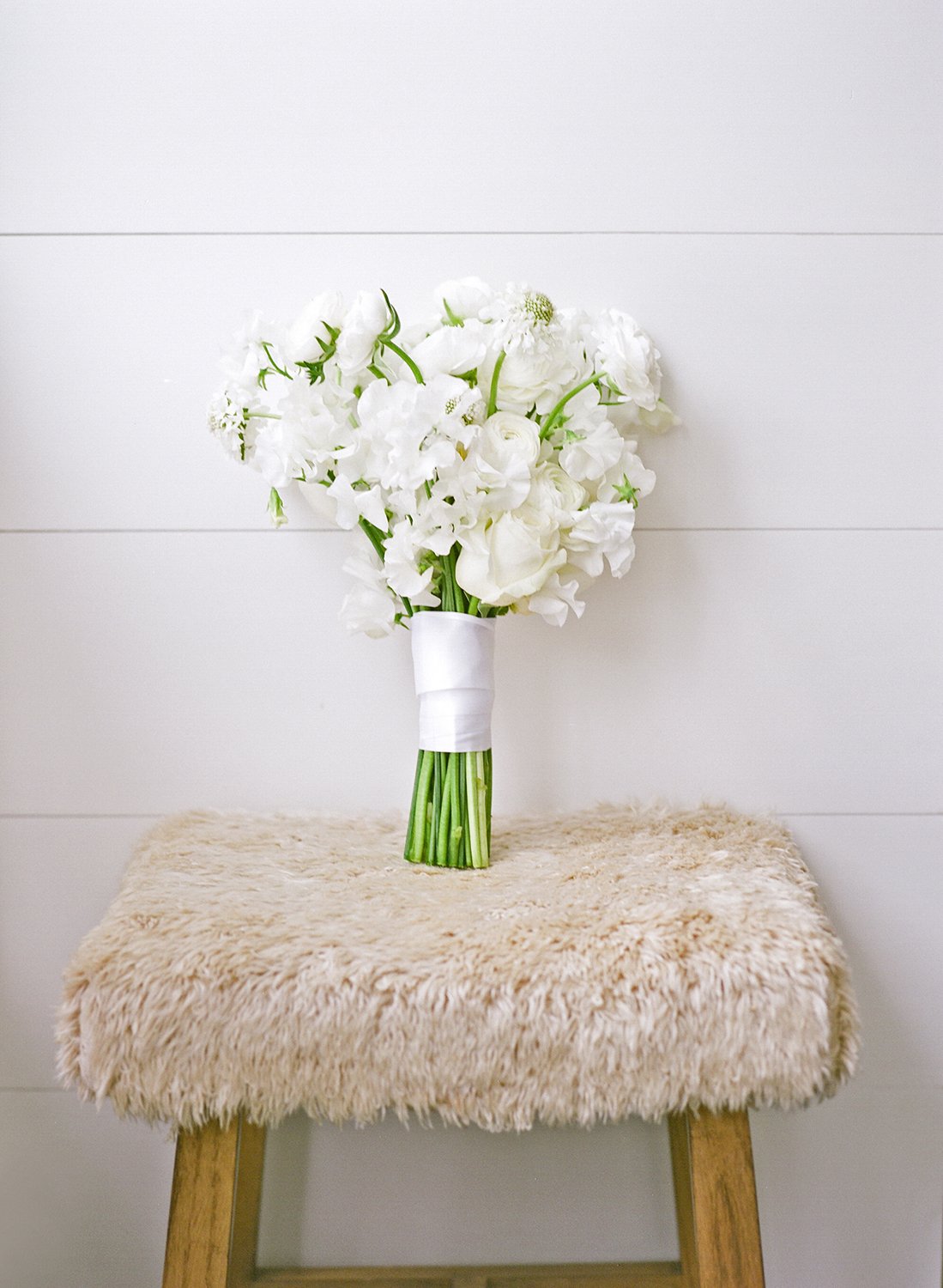 Coley & Teddy's wedding at the Aspen Chapel and Hotel Jerome: the bridal bouquet on a sheepskin stool