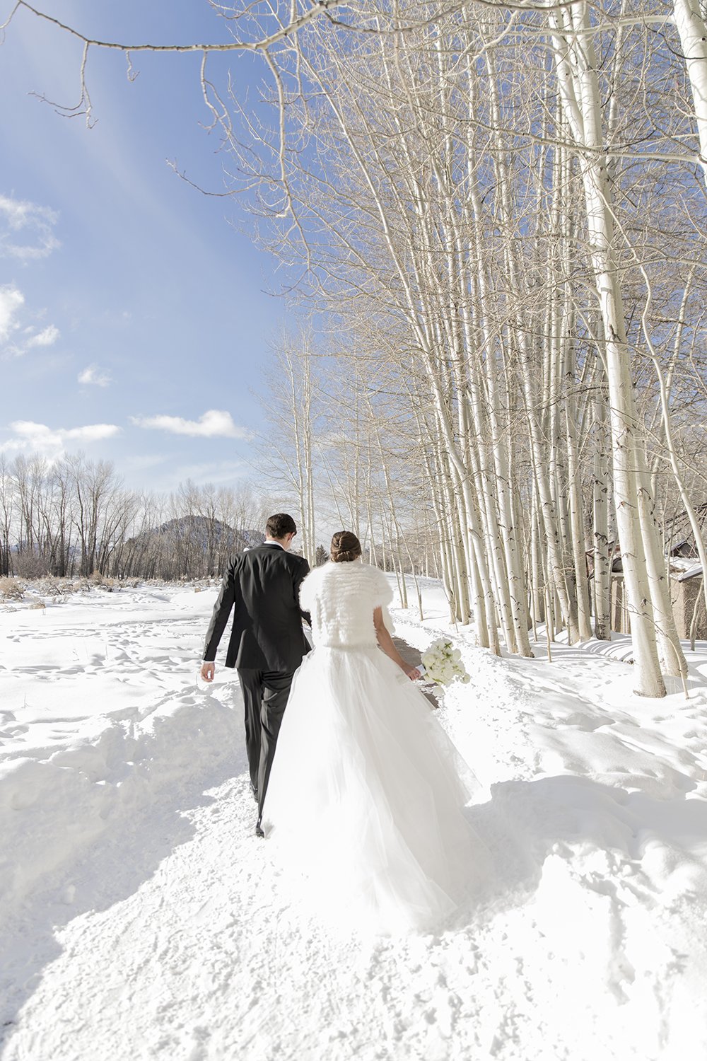 Coley & Teddy's wedding at the Aspen Chapel and Hotel Jerome: the couple walking through the snow