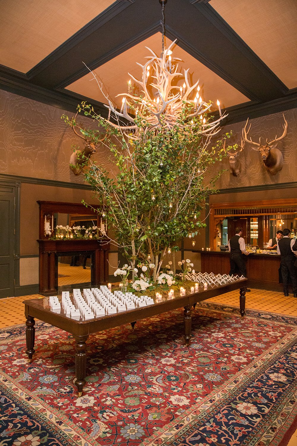 Coley & Teddy's wedding at the Aspen Chapel and Hotel Jerome: the Antler Bar with a towering branch arrangement