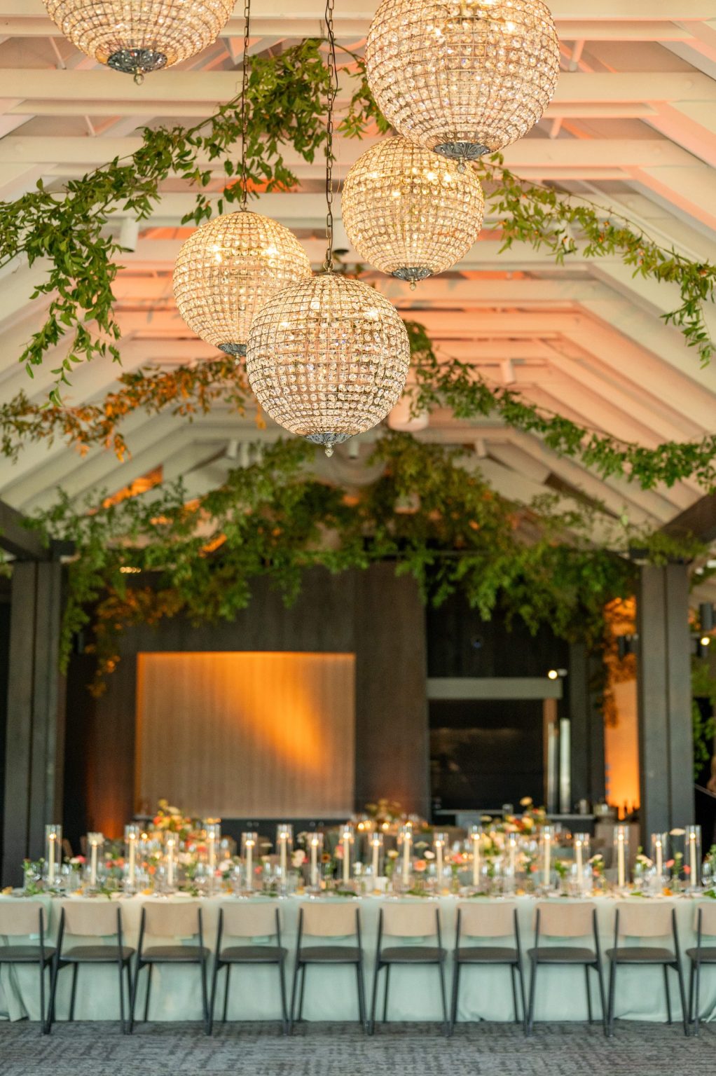 Haley and Sam's wedding at Buttermilk Mountain Lodge, Aspen: Crystal globe chandeliers and smilax garlands over a long candlelit table