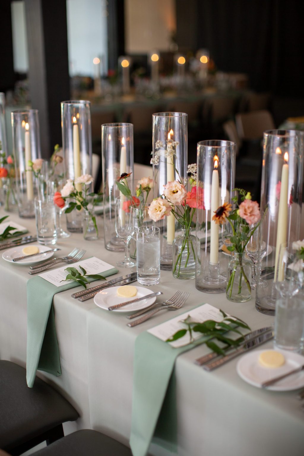 Haley and Sam's wedding at Buttermilk Mountain Lodge, Aspen: Long table with tapers in tall glass and single-stem bud vases on sage linen