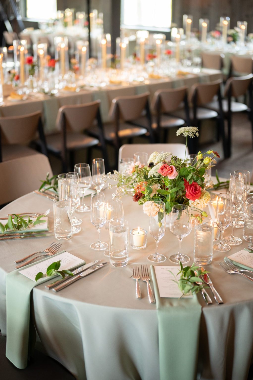 Haley and Sam's wedding at Buttermilk Mountain Lodge, Aspen: Round table with a low wildflower centerpiece and sage napkins