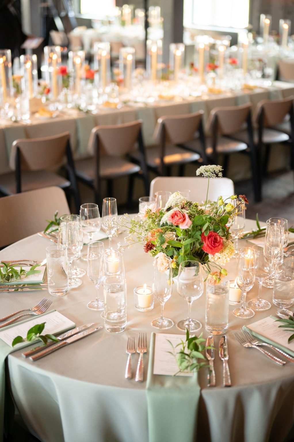 Haley and Sam's wedding at Buttermilk Mountain Lodge, Aspen: Round table with a wildflower centerpiece, long tables behind