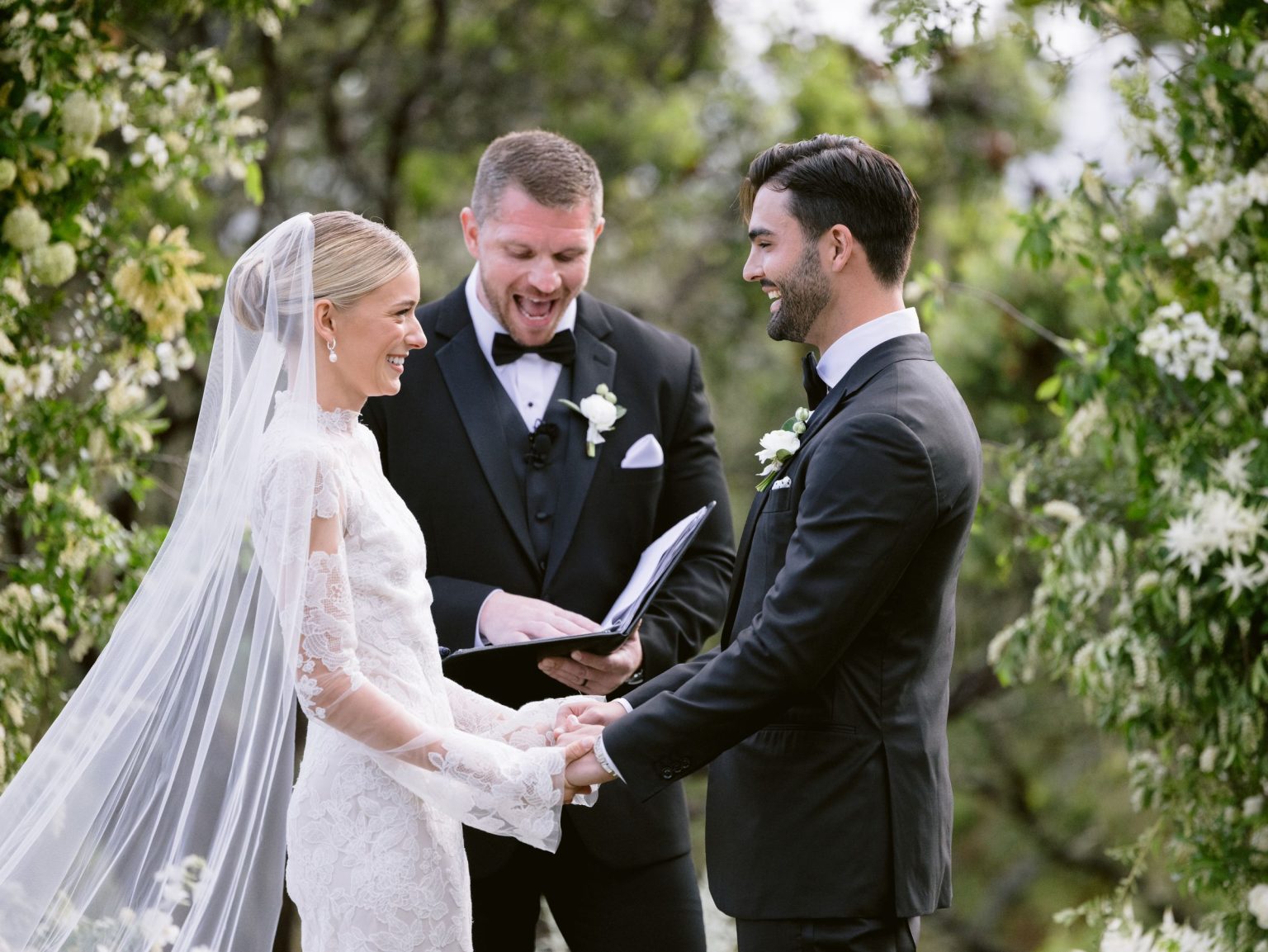 Sydney and Keaton's wedding at Montage Healdsburg, California: vows under the floral arch on the Oak Lawn