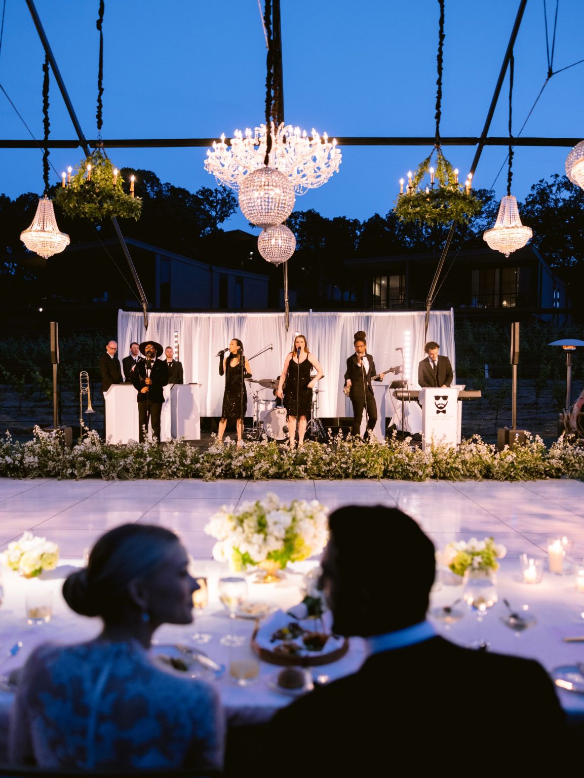 Sydney and Keaton's wedding at Montage Healdsburg, California: the band beneath the chandeliers at dusk