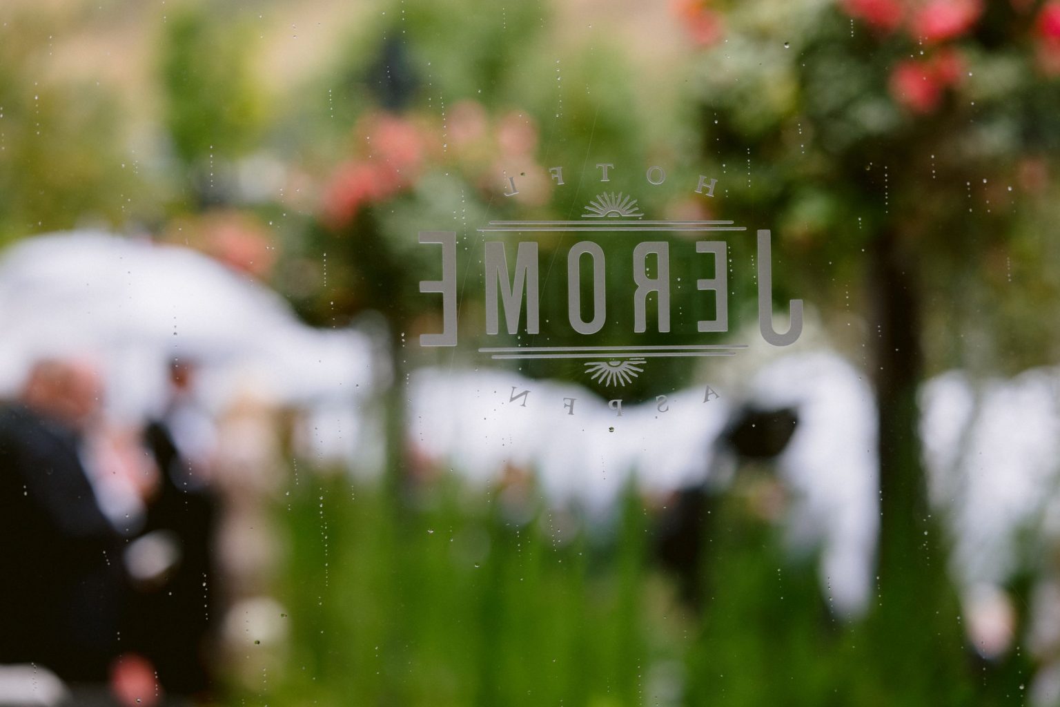 Addy & Nick's wedding at Hotel Jerome, Aspen: white florals in the Hotel Jerome courtyard on a rainy afternoon