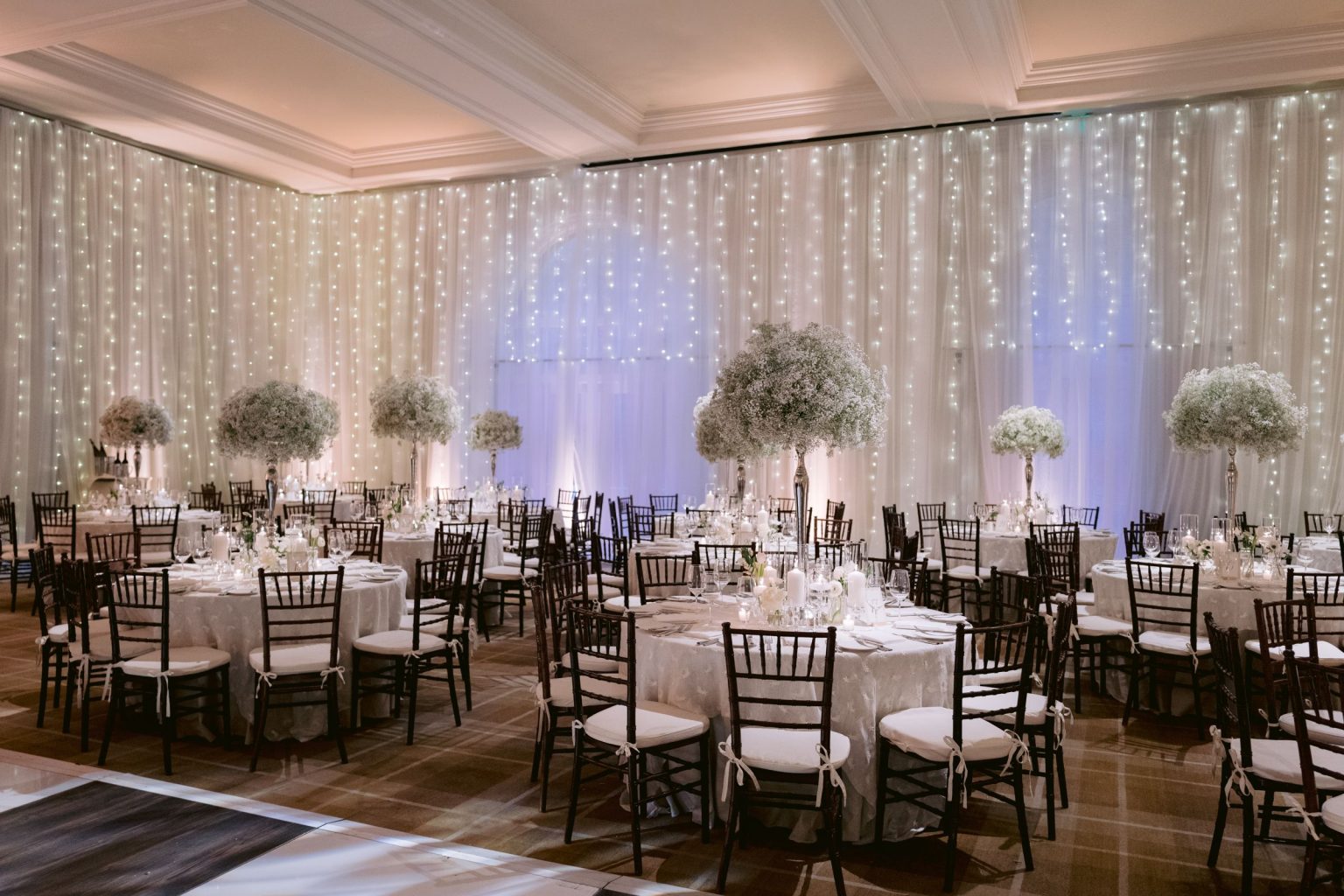 Addy & Nick's wedding at Hotel Jerome, Aspen: the Hotel Jerome ballroom with draped walls and baby's breath centerpieces