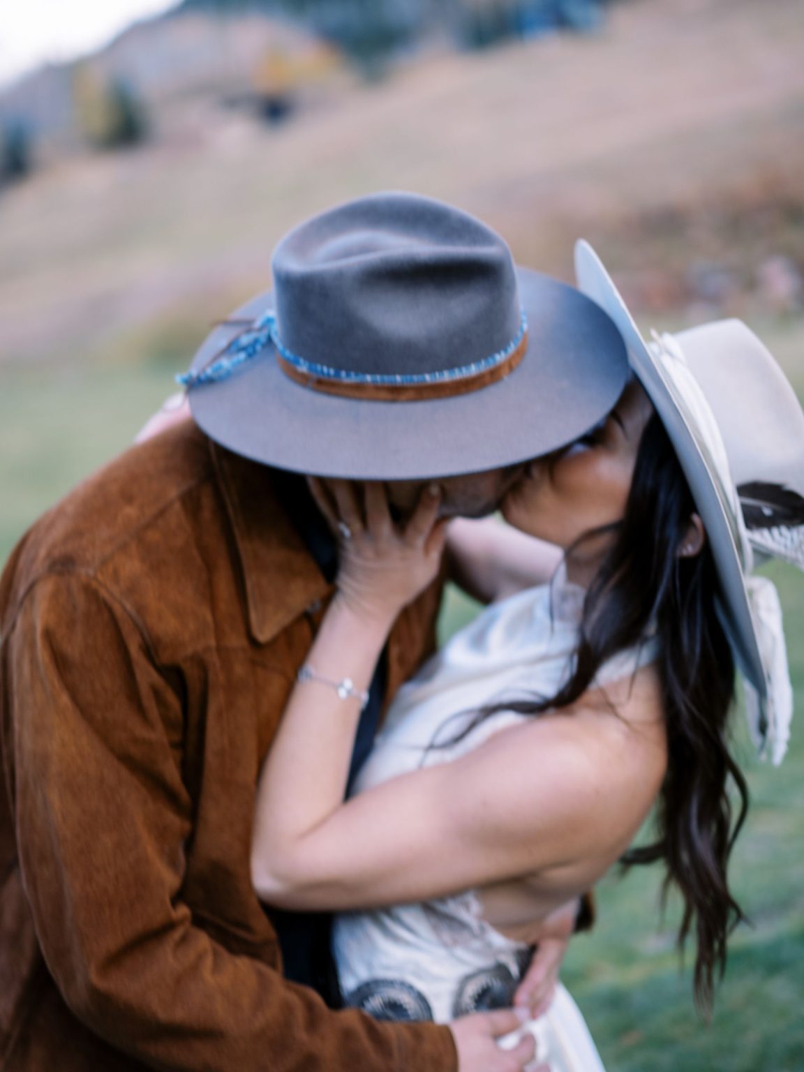 Abby & David's wedding at Hotel Jerome, Aspen: a kiss beneath the cowboy hats