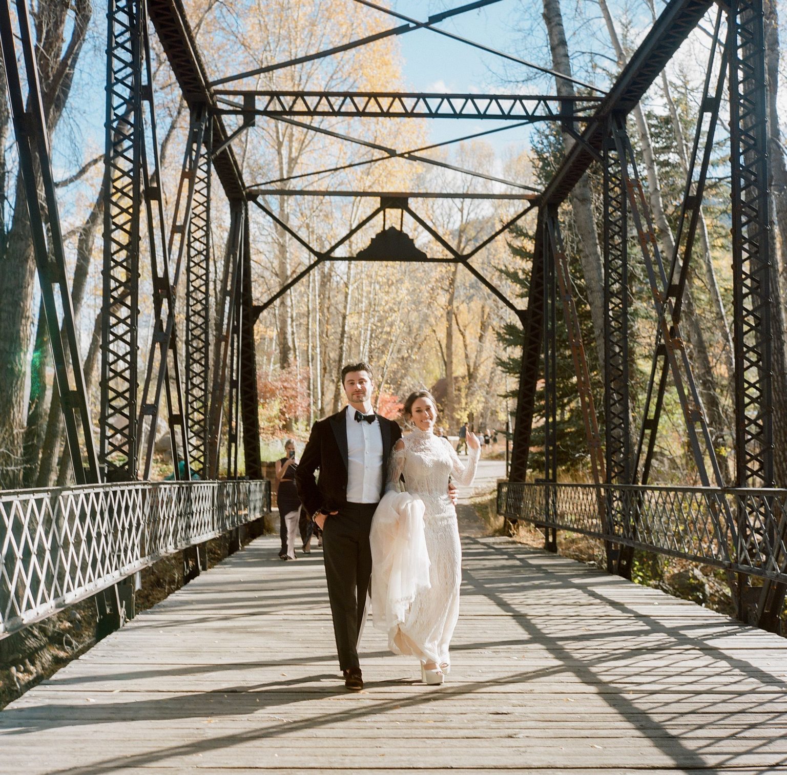Abby & David's wedding at Hotel Jerome, Aspen: the couple walking across the bridge