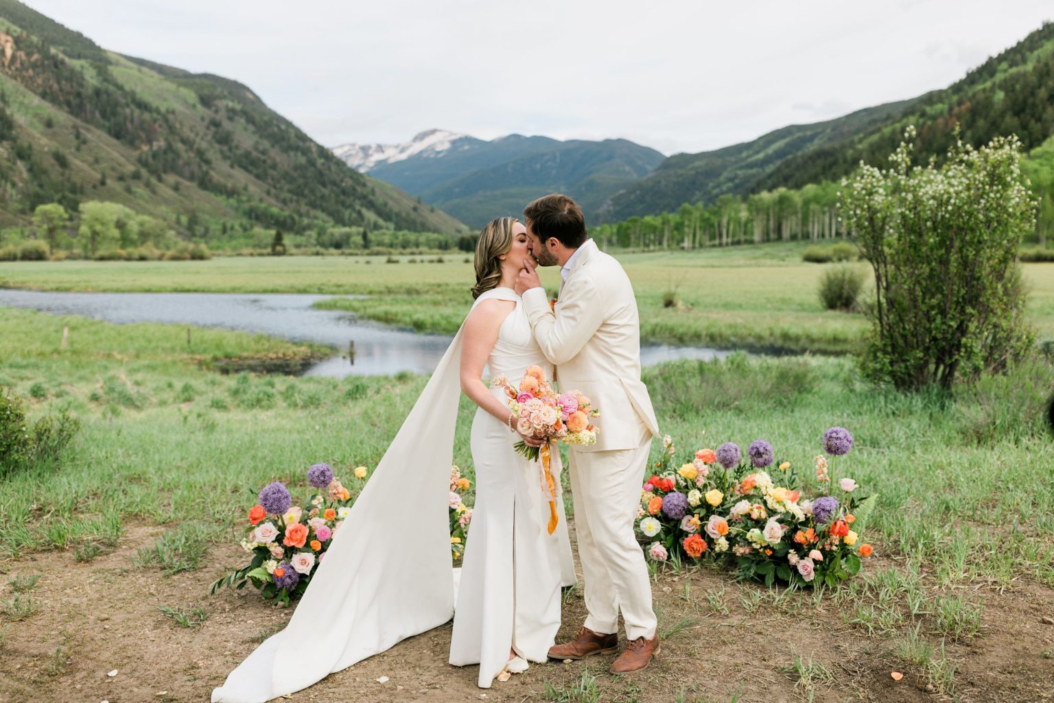 Julie & Tobias's wedding on the Northstar Preserve, Aspen: a kiss beside the ceremony florals