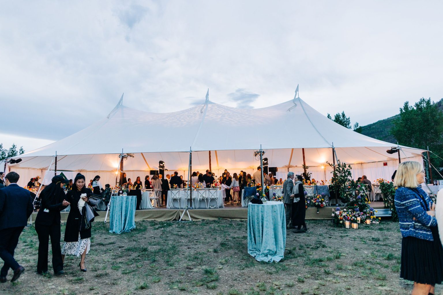 Julie & Tobias's wedding on the Northstar Preserve, Aspen: guests outside the tent at dusk
