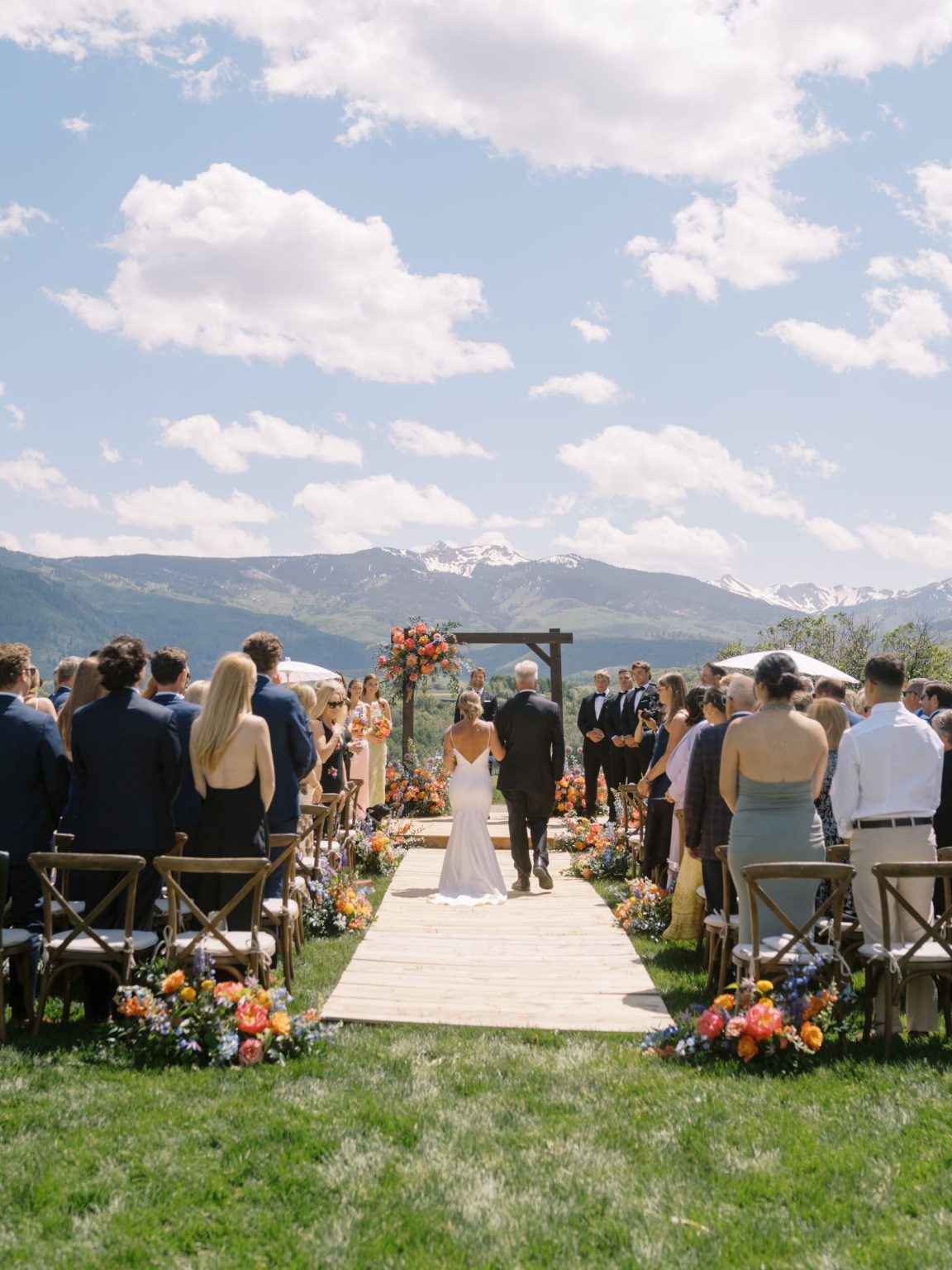 Clare and Kobe's McCabe Ranch wedding in Old Snowmass, Colorado: the bride walking down the aisle toward the mountains