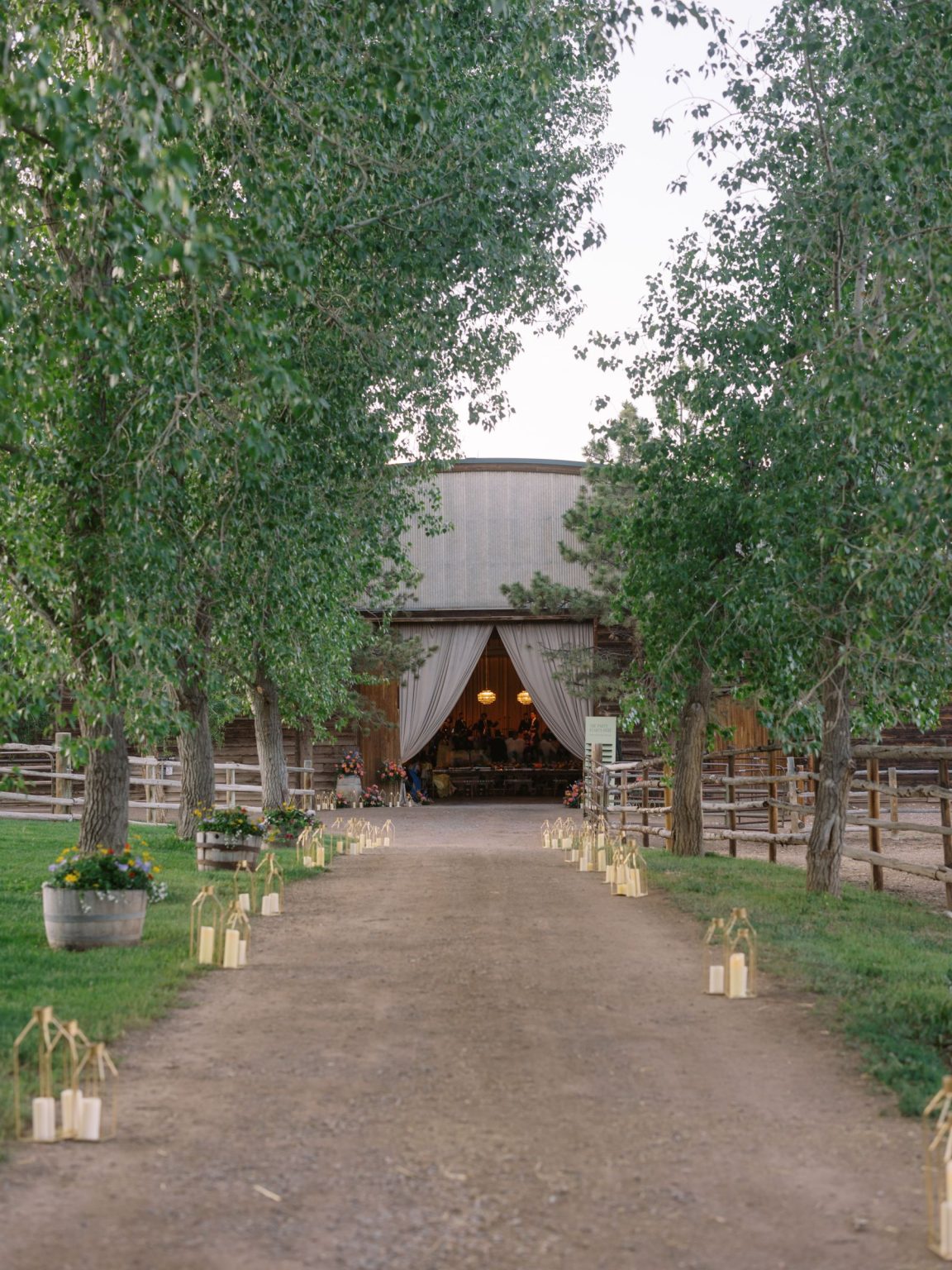 Clare and Kobe's McCabe Ranch wedding in Old Snowmass, Colorado: lantern-lined path to the draped barn entrance
