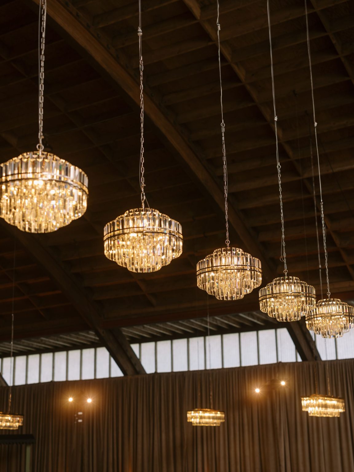 Clare and Kobe's McCabe Ranch wedding in Old Snowmass, Colorado: crystal chandeliers in the barn