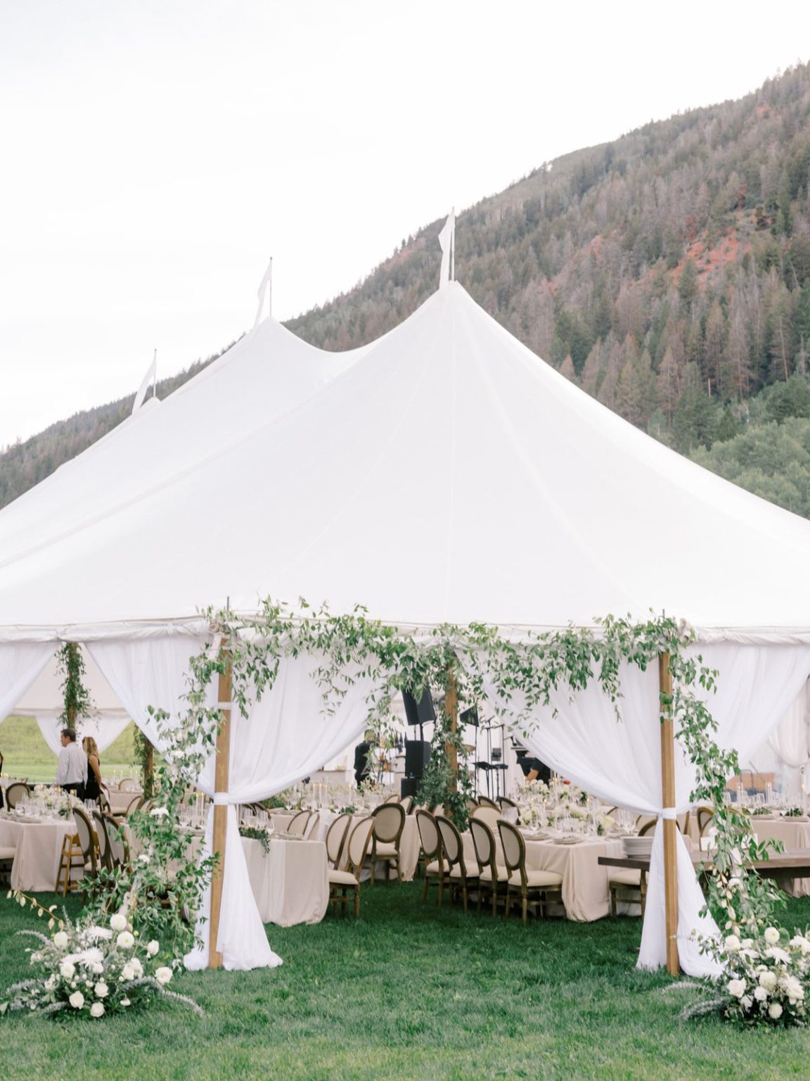 Meredith and Jason's wedding at T Lazy 7 Ranch, Aspen: the draped tent entry with greenery and white florals
