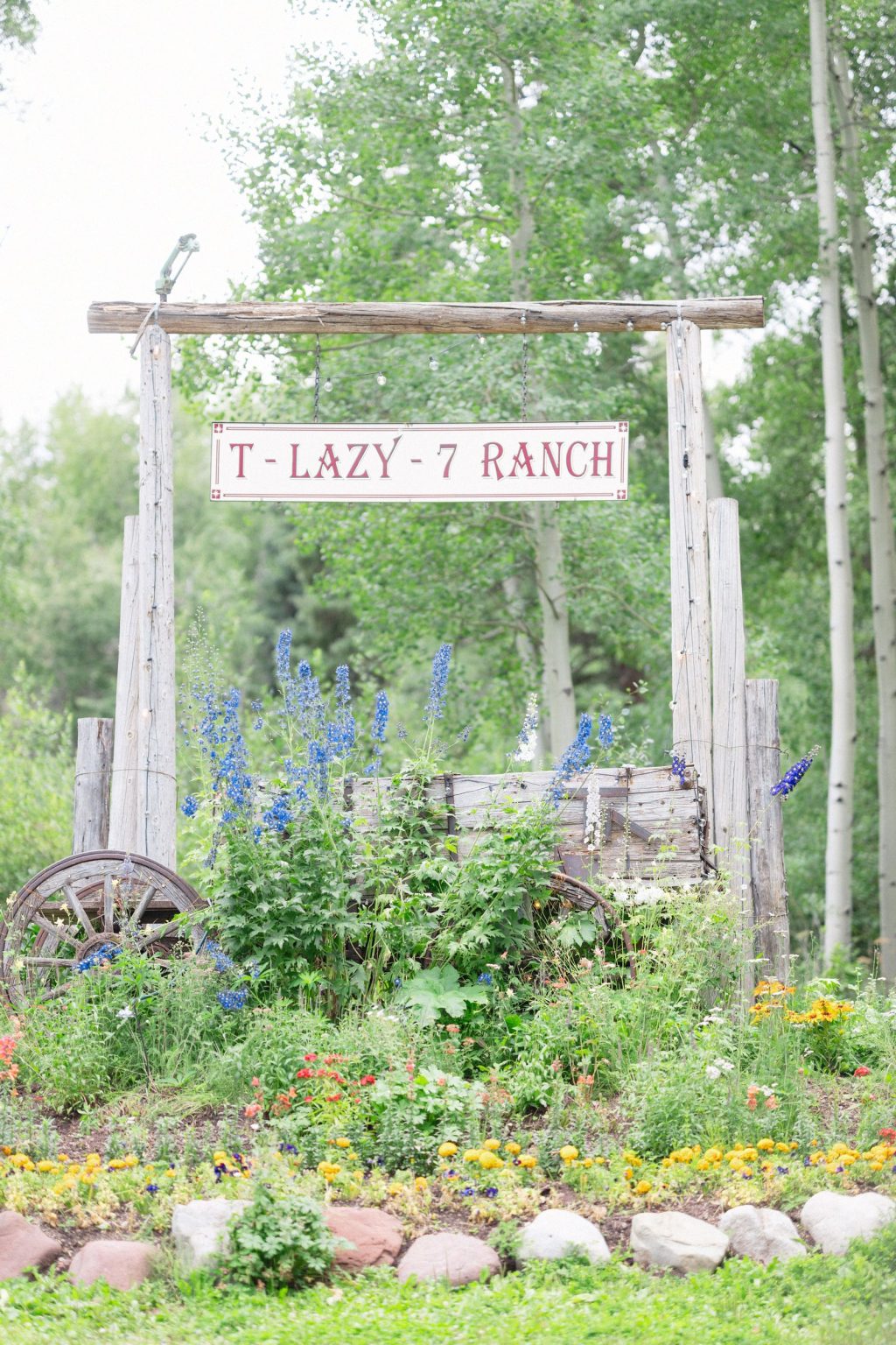 A wildflower wedding at T Lazy 7 Ranch, Aspen: the ranch gate framed by delphinium and garden blooms