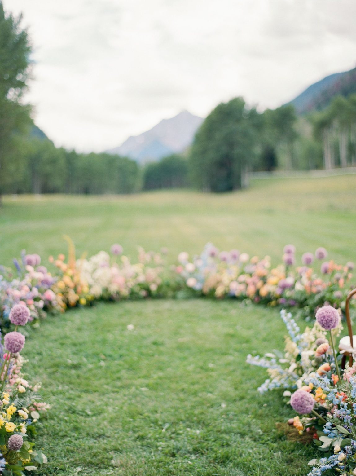 A wildflower wedding at T Lazy 7 Ranch, Aspen: a ring of pastel florals marking the ceremony space