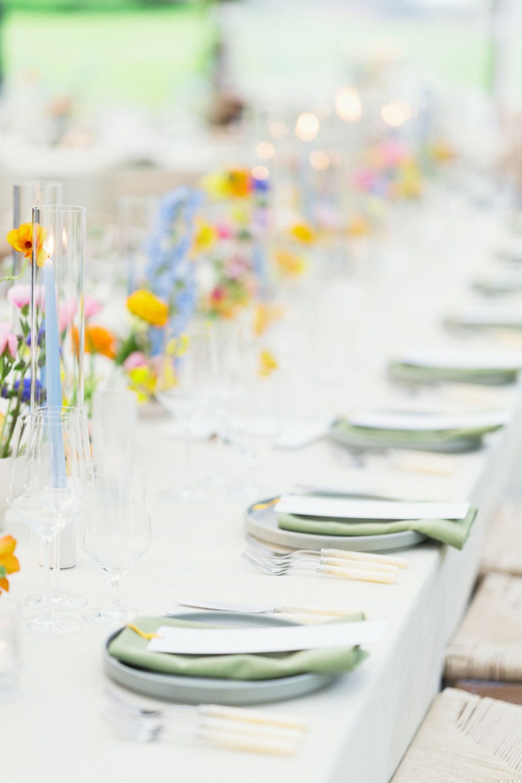A wildflower wedding at T Lazy 7 Ranch, Aspen: a line of bud vases and tapers down a long table