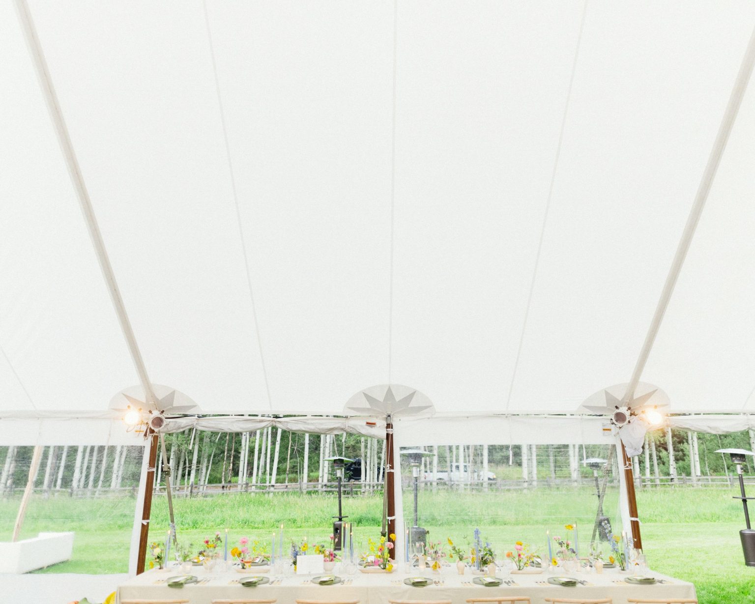 A wildflower wedding at T Lazy 7 Ranch, Aspen: the tent interior with views out to the aspens