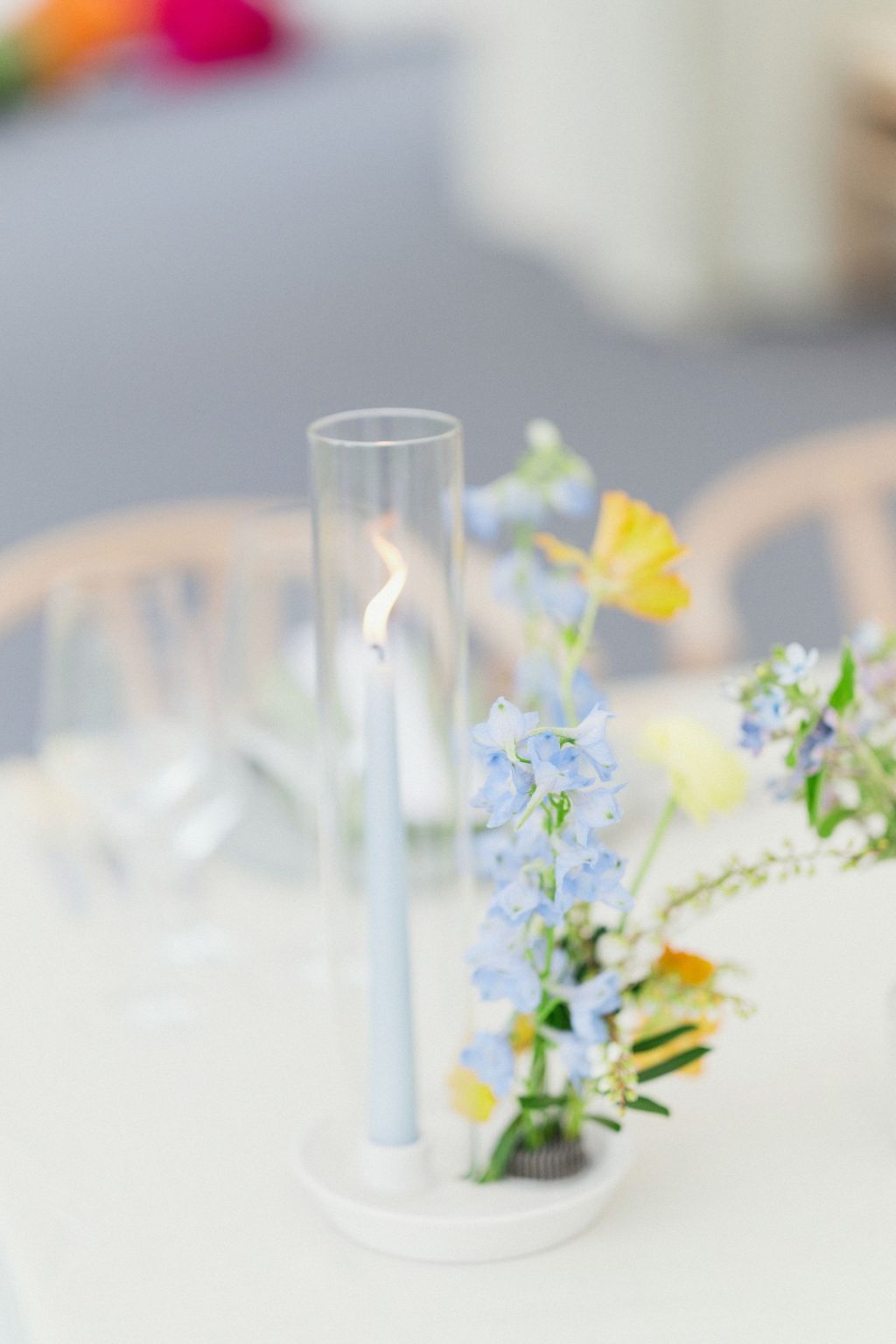 A wildflower wedding at T Lazy 7 Ranch, Aspen: delphinium and a pale blue taper in a glass hurricane