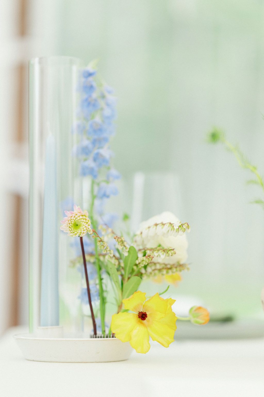 A wildflower wedding at T Lazy 7 Ranch, Aspen: delphinium and a single yellow bloom under glass