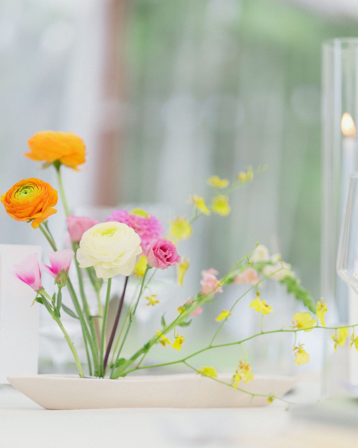 A wildflower wedding at T Lazy 7 Ranch, Aspen: ranunculus, oncidium, and spray roses in a low ceramic dish