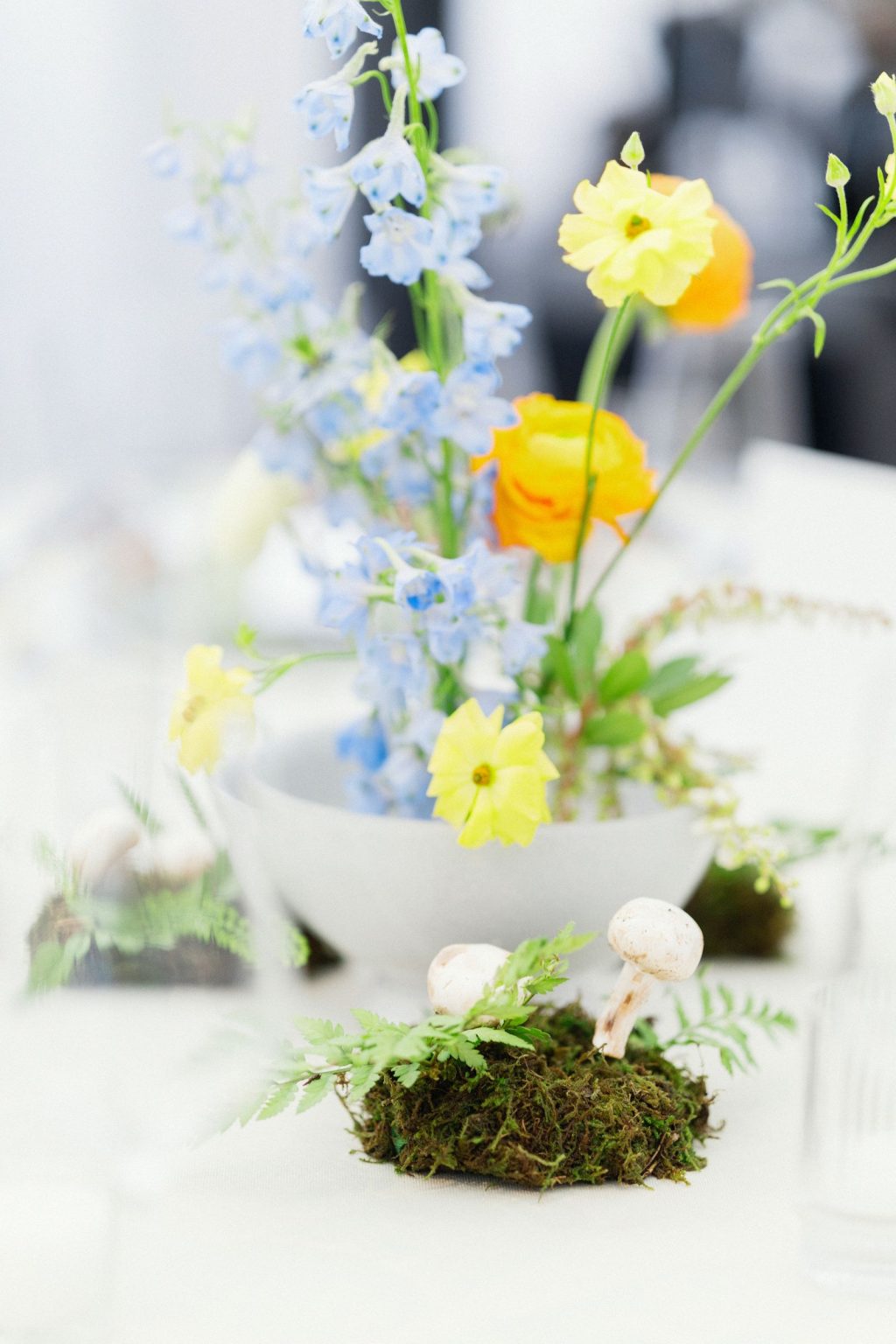 A wildflower wedding at T Lazy 7 Ranch, Aspen: delphinium and ranunculus rising from a bed of moss