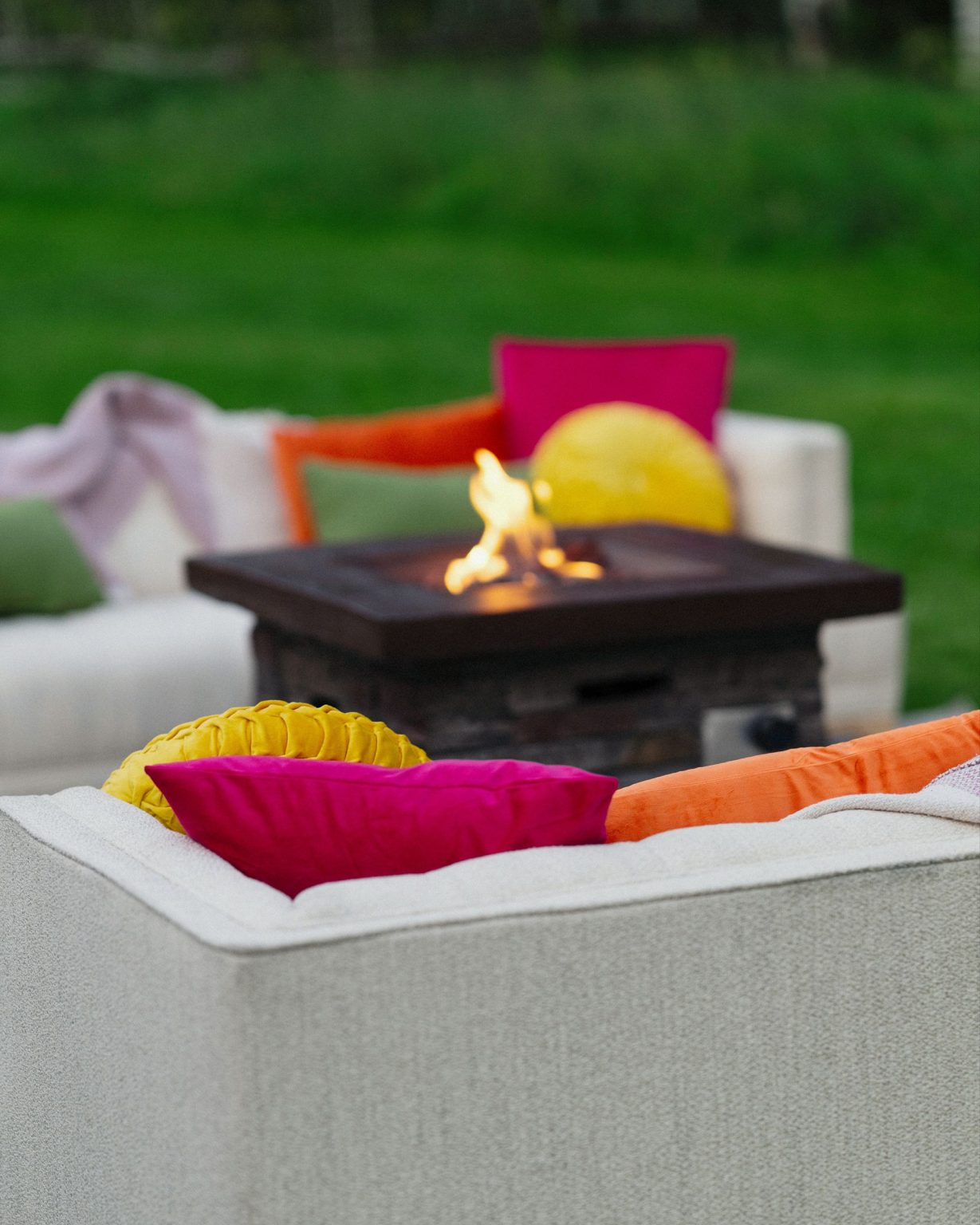 A wildflower wedding at T Lazy 7 Ranch, Aspen: a lounge with a fire table and bright pillows